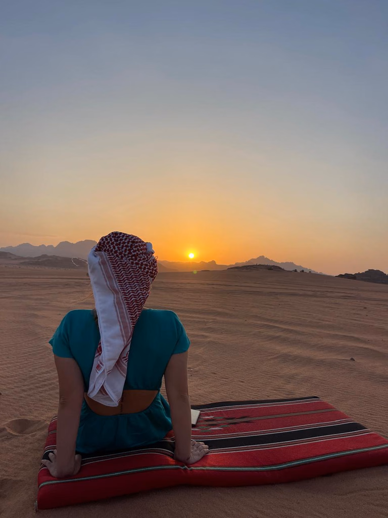 Woman watching the sunset at a sunset tour in wadi rum, jordan