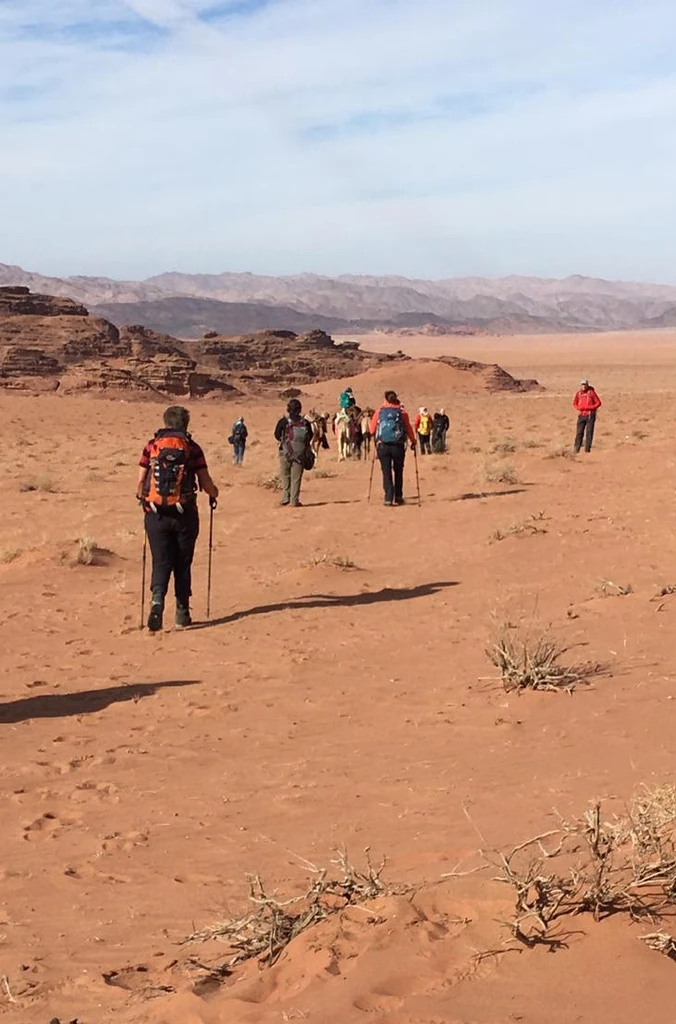 Trekking tour with guests walking down a hill in Wadi Rum Desert, Jordan