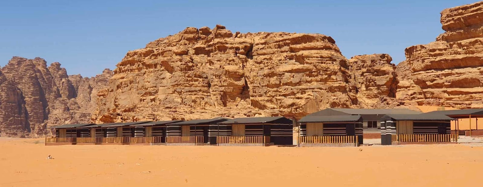 Rum Under The Stars Camp beneath sandstone cliffs in Wadi Rum