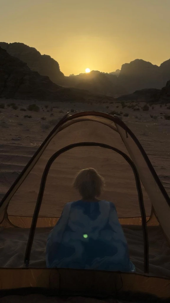 Wadi Rum, Jordan - A guest inside a tent in the desert at sunset
