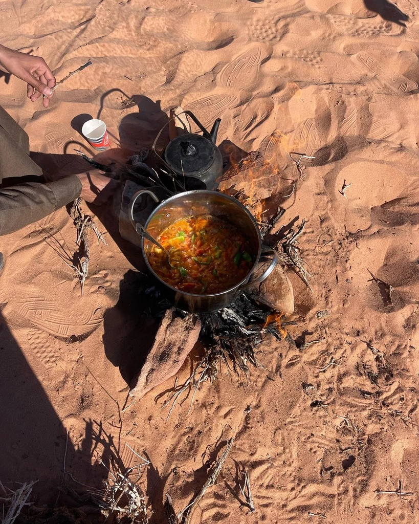 Large cooking pot heating over a fire in a sandstone canyon