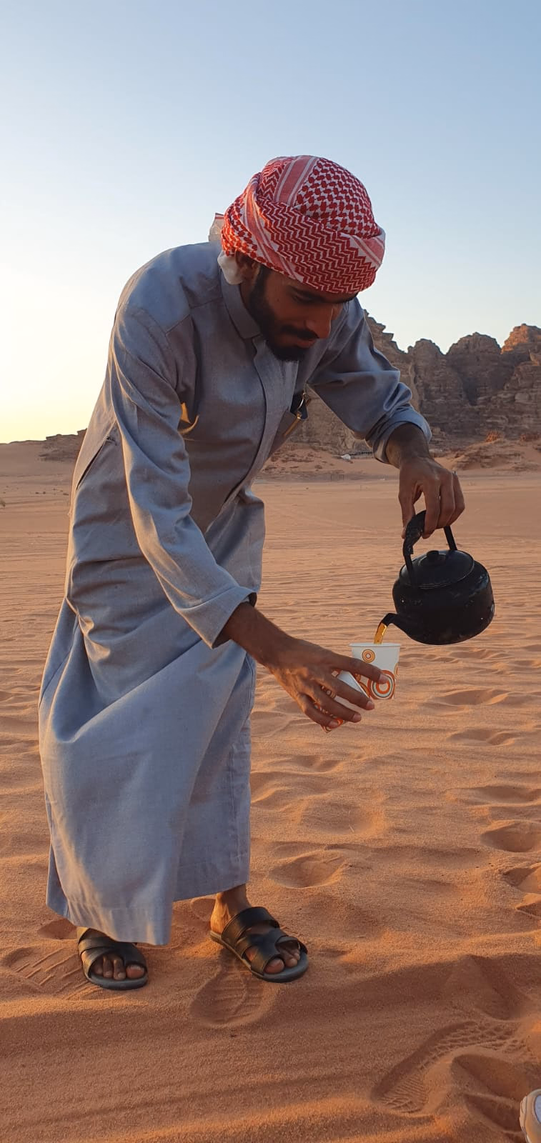 Bedouin Guide pouring tea in the wadi rum desert, jordan