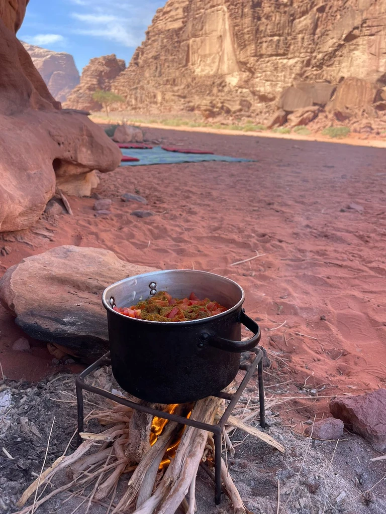 Traditional black cooking pot suspended over an open fire
