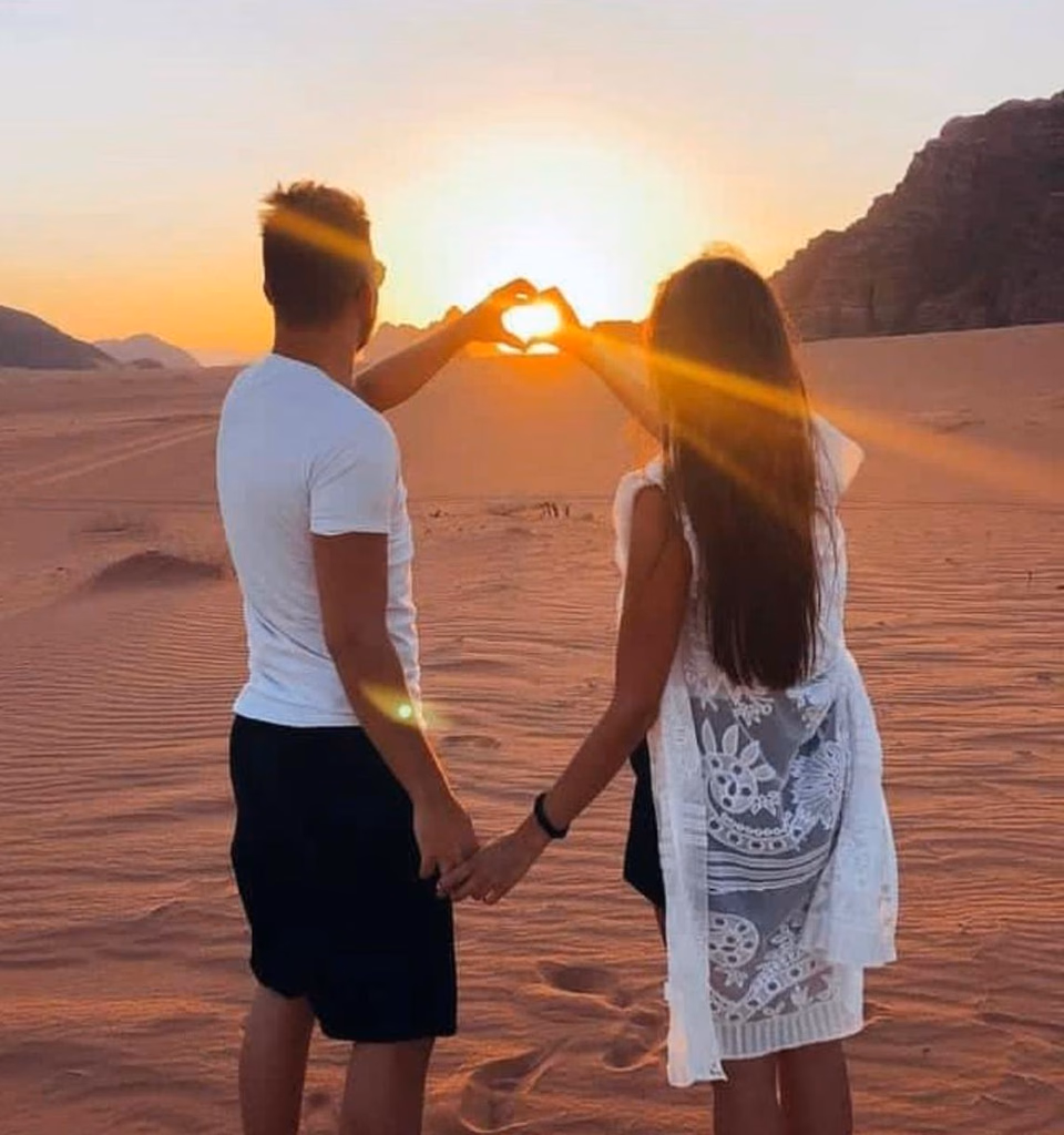 Couple holding hands at a sunset in wadi rum, jordan