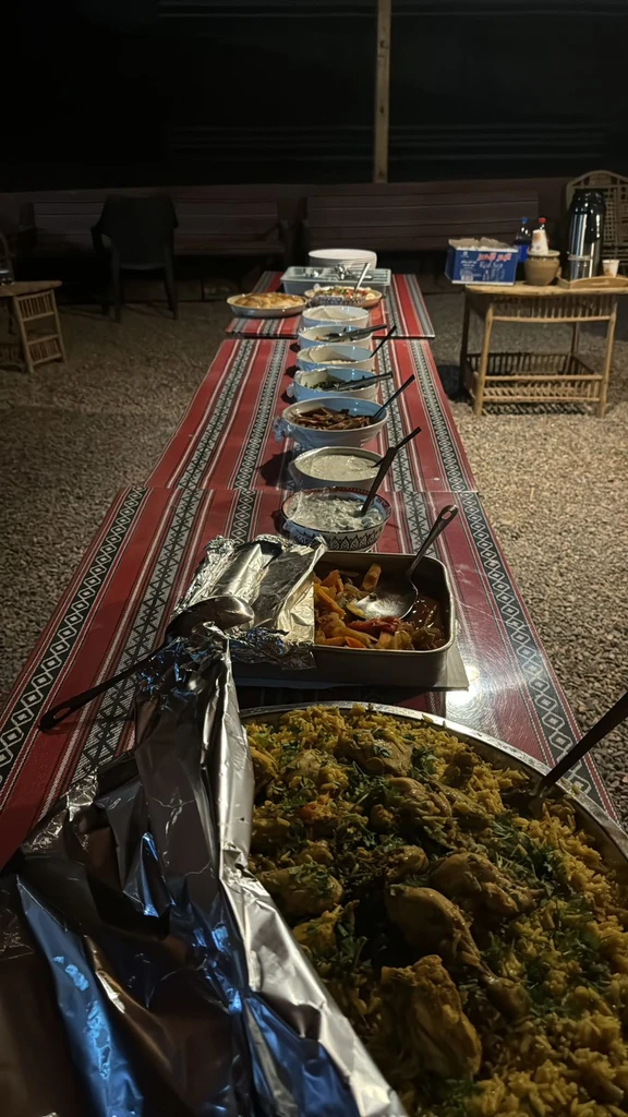 Long communal dinner setting on traditional woven carpets
